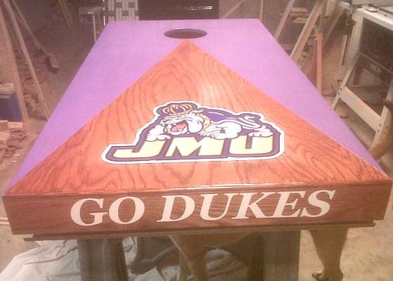 Custom vinyl lettering and decal on a corn hole board. Custom vinyl lettering and decal on a corn hole board.